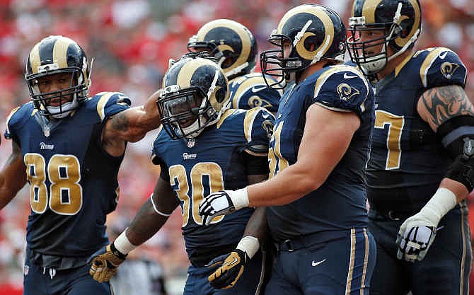 St. Louis Rams running back Zac Stacy (30) celebrates with teammates, including tight end Lance Kendricks (88) and center Tim Barnes (61), after scoring against the Tampa Bay Buccaneers during the first quarter of an NFL football game Sunday, Sept. 14, 2014, in Tampa, Fla. 