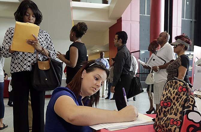 In this Aug. 19, 2014 file photo, Jessica Pimentel, of Hollywood, Fla., fills out a job application during a job fair in Sunrise. Fla. Optimism among chief executives at the largest U.S. companies fell in the July-September quarter after reaching a two-year high in the previous quarter. 
