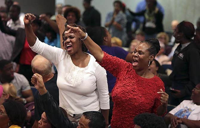 Protesters chant at a meeting of the St. Louis County Council on Tuesday, Sept. 16, 2014, in Clayton, Mo. Protesters, seeking the immediate arrest of Ferguson police officer Darren Wilson who fatally shot unarmed 18-year-old Michael Brown, disrupted a government meeting Tuesday, renewing calls to remove the county prosecutor investigating the case.