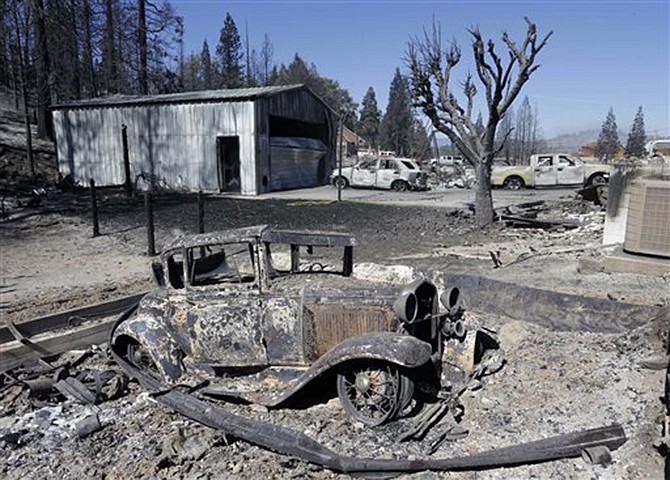 An antique car sits among the ruins of a burned out garage that was destroyed by a fire in Weed, California, Tuesday. In just a few hours Monday, wind-driven flames destroyed or damaged roughly 100 homes. 