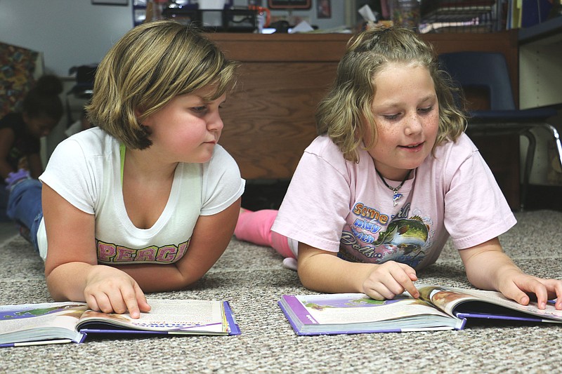South Callaway fourth grade students Erika Creason and Kara Evans read a short biography in their reading text book during class Thursday.