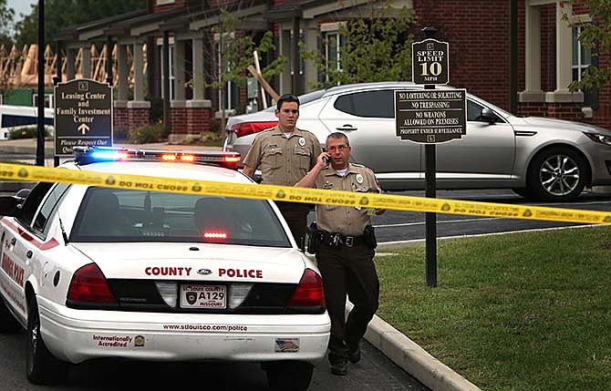 St. Louis County police officers investigate the scene of a fatal police officer involved shooting on Thursday, Sept. 18, 2014 in Jennings, Mo. St. Louis County Police Chief Jon Belmar said the officers fired a combined 25 shots at the suspect. The officers told Belmar the suspect tried to fire at them, but the rifle the suspect had, jammed. No casings from the suspect's .22-caliber rifle were found. (AP Photo/St. Louis Post-Dispatch, David Carson)