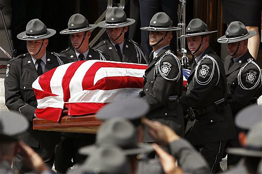 An honor guard carries the casket of Pennsylvania State Trooper Cpl. Bryon Dickson  from his funeral service, Thursday, in Scranton, Pennsylvania. Dickson was killed on Friday night in an ambush shooting at the state police barracks in Blooming Grove Township. Authorities are looking for 31-year-old Eric Frein, of Canadensis, who has been charged with killing one trooper and wounding another outside the barracks. 