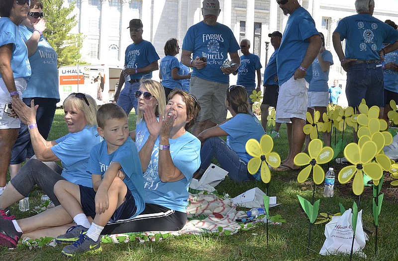 Members of Farris Wheels of Hope applaud other members of their team as they finish a 3.1-mile Walk to End Alzheimer's Sunday at the Capitol. Sitting, from left, are Sandy Rackers, Holts Summit; Wyatt Jordan, 7, New Bloomfield; Chelsey Rackers, Holts Summit; and team captain Vicki Clark. 
