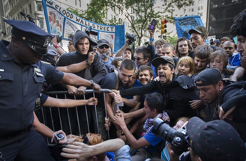 Protestors attempt to wrestle a barricade blocking them from Wall Street away from police officers during a march demanding action on climate change.