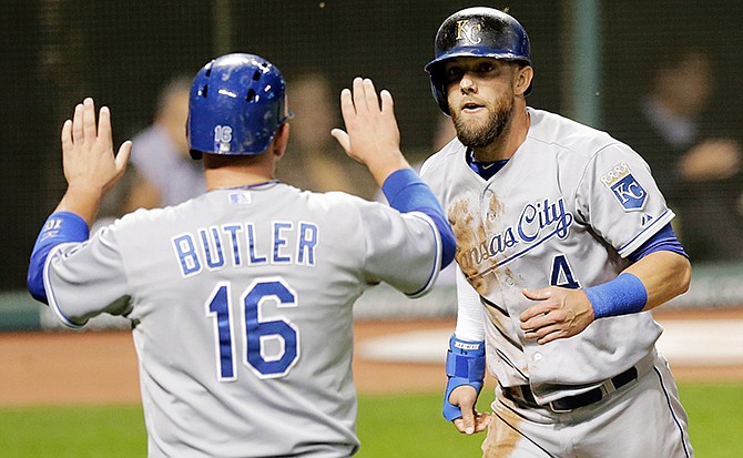 Kansas City Royals' Billy Butler, left, and Alex Gordon congratulate each other after both score on a two-run double hit by Salvador Perez in the fifth inning of a baseball game, Tuesday, Sept. 23, 2014, in Cleveland. 