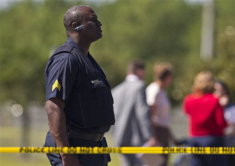 A police officer stands guard at a UPS warehouse on Tuesday in Birmingham, Ala. A UPS employee opened fire Tuesday morning inside one of the company's warehouses in Alabama, killing two people before taking his own life, police said.