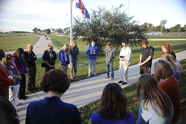 About two dozen students gathered at the Russellville High School flagpole Wednesday to participate in the international See You At The Pole. Sophomore Cory Libbert led the Russellville students with scripture from Ephesians 6:10-20 and a devotion to about finding strength in God before the group prayed for special requests.