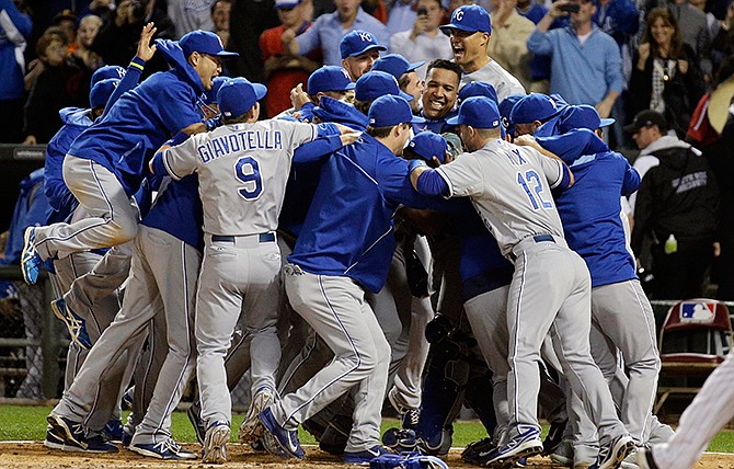 Kansas City Royals' Nori Aoki, of Japan, left, jumps as he celebrates with teammates after the Royals defeated the Chicago White Sox 3-1 in a baseball game in Chicago on Friday, Sept. 26, 2014. 