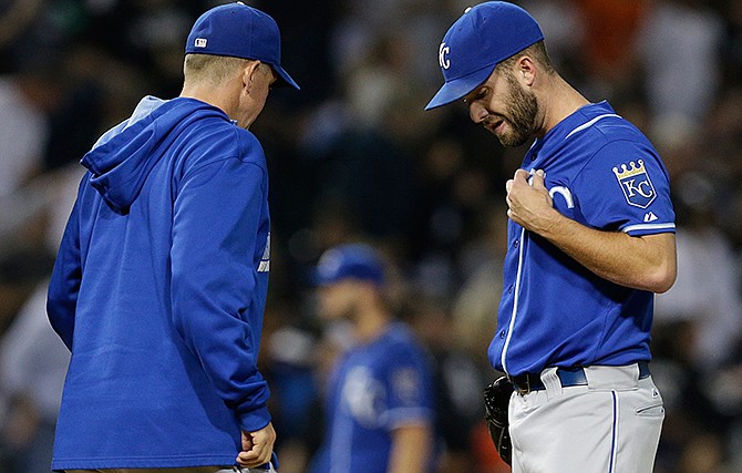 Kansas City Royals starter Danny Duffy, right, reacts as he listens to pitching coach Dave Eiland after Chicago White Sox's Jose Abreu hit a two-run home run during the first inning of a baseball game in Chicago on Saturday, Sept. 27, 2014.