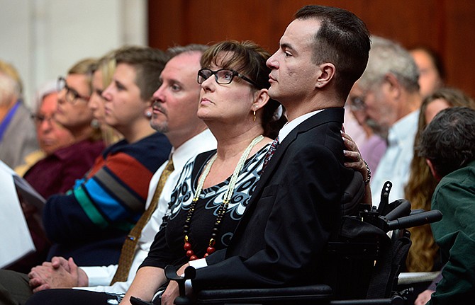 Brandon Coats, a quadriplegic medical marijuana patient who was fired by the Dish Network after failing a drug test more than four years ago, right, waits for the proceedings to begin with his mother, Donna Scharfenberg, at the Colorado Supreme Court in Denver on Tuesday, Sept. 30, 2014. Coats' case highlights the clash between state laws that are increasingly accepting of marijuana use and employers' drug-free policies that won't tolerate it. 