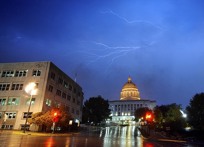 Streaks of lightning flash across the sky over the dome of the Missouri Capitol as the day's second round of severe thunderstorms enter the region Wednesday evening.