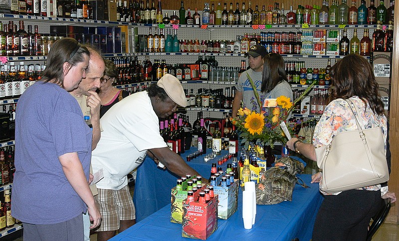 Joining in for the 35th anniversary of Mr. G's Liquor store are customers looking over the selection of wines available for tasting on Saturday, Sept. 27.