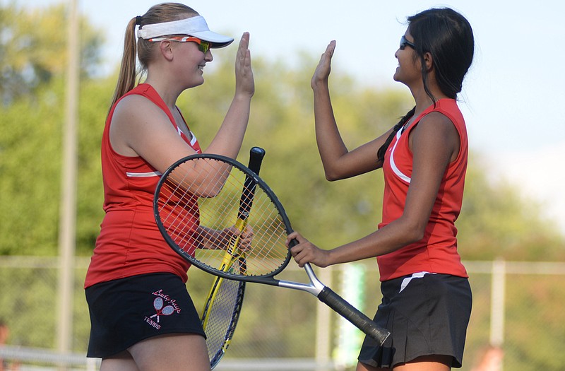 Jefferson City teammates Erica Dunn (left) and Athira Nambiar, celebrate after winning their doubles match during Tuesday afternoon's team district dual against the Rolla Lady Bulldogs at Washington Park. Dunn and Nambiar won their match 8-2 as Jefferson City posted a 5-0 victory against Rolla to advance to the district tournament final.