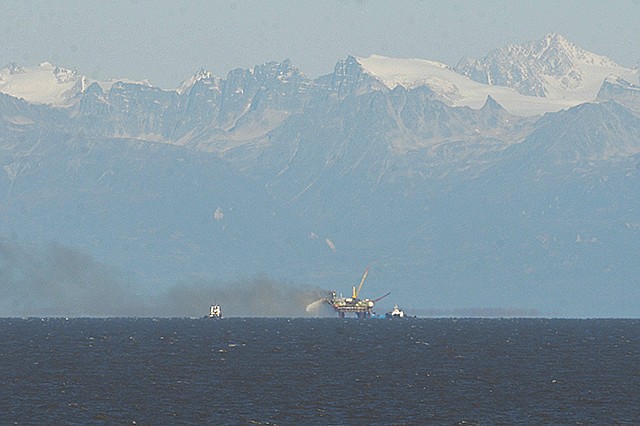 A plume of smoke rises from Hilcorp's Baker platform on Thursday near Nikiski, Alaska. The fire appeared to be out later in the morning,  but vessels at the scene were still battling smoke, the Coast Guard said.