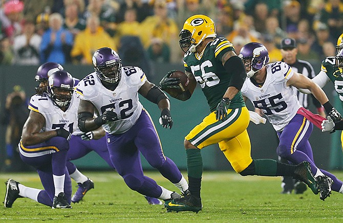 Green Bay Packers' Julius Peppers runs back an interception 49-yards for a touchdown during the first half of an NFL football game against the Minnesota Vikings Thursday, Oct. 2, 2014, in Green Bay, Wis. 