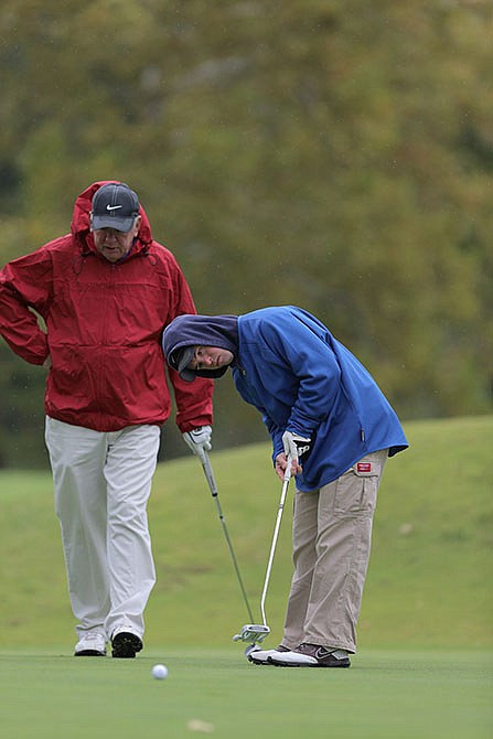 Special Olympics athlete Nick McMullen putts under the guidance of his father, Jerry McMullen, at Railwood Golf Club Friday.