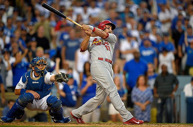 St. Louis Cardinals' Matt Carpenter, right, hits a three-RBI double as Los Angeles Dodgers catcher A.J. Ellis looks on in the seventh inning of Game 1 of baseball's NL Division Series in Los Angeles, Friday, Oct. 3, 2014.