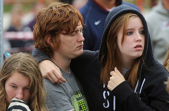 Joplin High School senior Cory Banta, left, and sophomore Alissa Ross comfort each other during a speech by Joplin Superintendent CJ Huff during a dedication ceremony for a combined high school and vocational school that replaces one destroyed by a deadly tornado more than three years ago, Friday, Oct. 3, 2014, in Joplin, Mo.