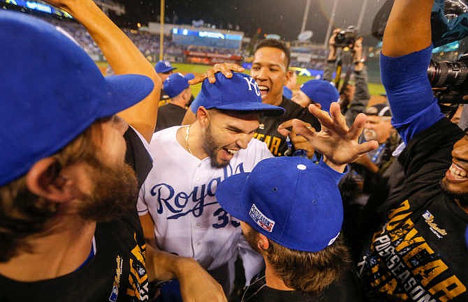 Kansas City Royals first baseman Eric Hosmer, center and catcher Salvador Perez, rear right, and teammates celebrate following Game 3 of baseball's AL Division Series in Kansas City, Mo., Sunday, Oct. 5, 2014. The Kansas City Royals defeated the Los Angeles Angels 8-3 to sweep the series. 
