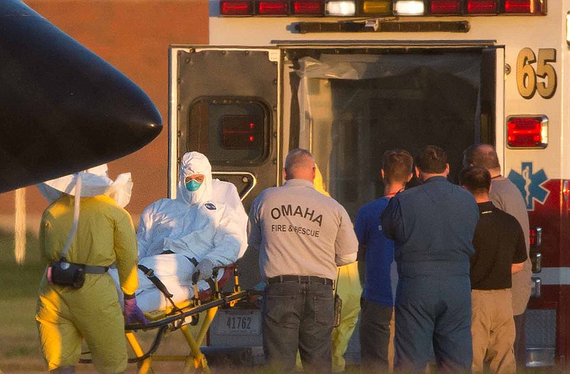 Ashoka Mukpo is loaded into an ambulance Monday after arriving in Omaha, Neb. Mukpo, an American video journalist who contracted Ebola while working in Liberia, was taken to Nebraska Medical Center for treatment.