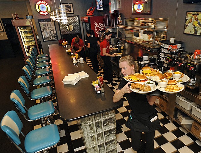 Oscar's Classic Diner waitress Sarah Hostetler delivers a table's order at the start of the Wednesday dinner service. Earlier in the day at the Jefferson City Area Chamber of Commerce Business Showcase, the popular Jefferson City diner was named the 2014 Small Business of the Year.