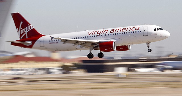In this 2010 photo, Virgin America's inaugural flight between Los Angeles an Dallas Fort Worth International Airport comes in for a landing in Grapevine, Texas. Passengers cherish Virgin America for its mood lighting, live TV, fancy cocktails and friendly flight attendants. That nice-guy approach to air travel wins awards and attracts a cult following, but may not fly with Wall Street.