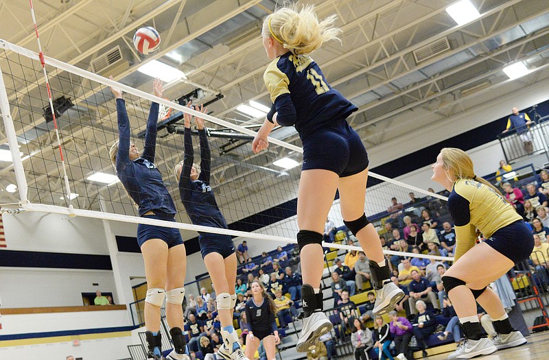 Helias' Laura Schieber (second from right) spikes the ball past two Father Tolton defenders during Thursday night's match at Rackers Fieldhouse. Covering the play for the Lady Crusaders is Abby Farrow.