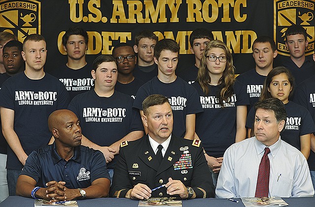 Lt. Cmdr. Ray Ferguson, Jr., middle, is flanked by LU President, Kevin Rome, left, and David Wilson, associate principal of Jefferson City High School and students in his first Military Leader class. Ferguson is professor of military science at Lincoln University and spoke at a press conference Thursday morning to the first group to go through the leadership at the nearby university.