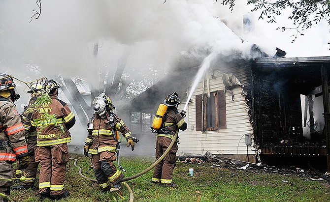 Russellville-Lohman and Cole County firefighters battle a house fire in Lohman early Friday afternoon. 