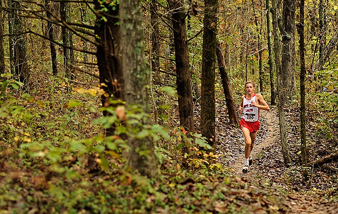 Jackson Schwartz of Jefferson City follows the wooded trail as he nears the finish in the boys varsity event Saturday during the Helias Catholic Invitational at Jefferson City's Binder Park.