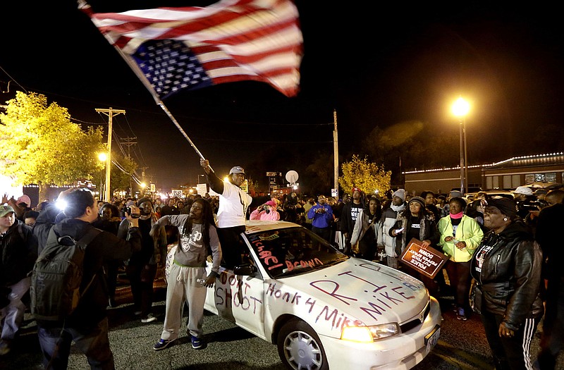 Protesters arrive at the Ferguson Police Department on Saturday for a rally in remembrance of Michael Brown in Ferguson.