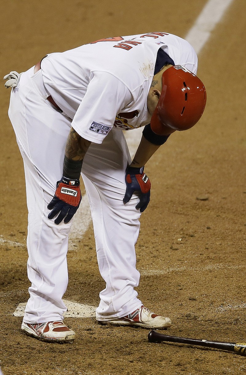 Yadier Molina bends over after an at-bat inthe sixth inning of Sunday night's NLCS Game 2 against the Giants at Busch Stadium. Molina left the game, but was able to practice Monday in San Francisco.