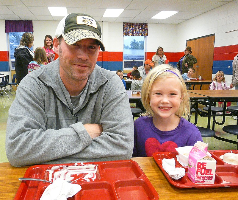 Andrew Hayden and Addasyn Haden, second grade, have breakfast together at Donuts for Dads held at the elementary on Friday.