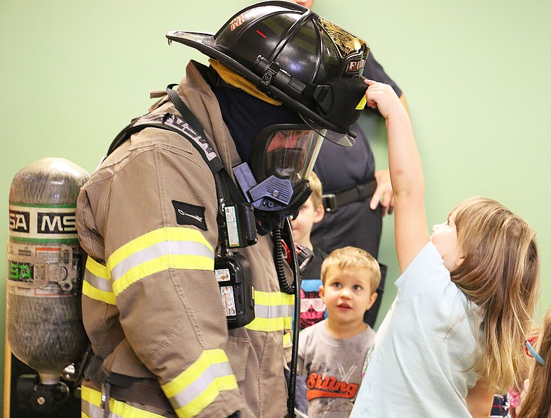 Fulton Firefighter Steve Knowles shows off his gear for preschoolers during story time at the Callaway County Public Library. "This is our favorite part of the job," Knowles said of visiting with kids about fire prevention.