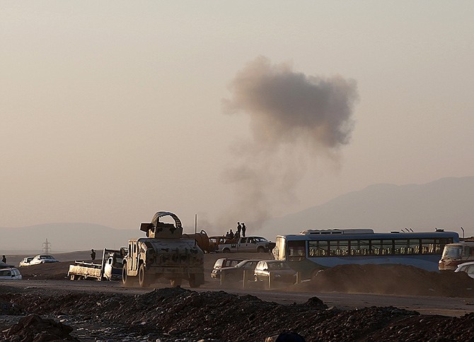 In this August photo, an armored vehicle belonging to Kurdish Peshmerga fighters rushes to a bombing site as smoke rises after airstrikes targeting Islamic State militants near the Khazer checkpoint outside of the city of Irbil in northern Iraq. The airstrikes were launched outside the Kurdish regional capital Irbil, and marked the first time U.S. forces have directly targeted the extremist Islamic State group, which controls large areas of Syria and Iraq. 