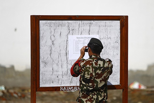 A Nepalese army soldier takes a photo of a patient's list at the Army hospital in Katmandu, Nepal, Thursday. At least 14 foreign trekkers have been rescued so far, including two from Hong Kong and 12 Israelis who were being treated at the Military Hospital in Katmandu. October is the most popular trekking season in Nepal, with thousands of foreigners hiking in the Himalayan mountains.