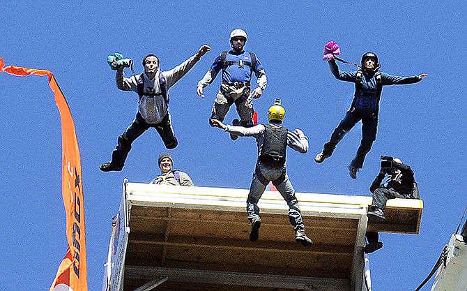 In this October 2010 photo, base jumpers jump off the New River Gorge Bridge in Fayetteville, West Virginia during Bridge Day. Tens of thousands of people will watch scores of parachutists, zip liners and rappellers during the annual Bridge Day festival on Saturday.