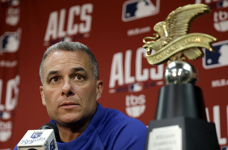 With the American League championship trophy by his side, Royals general manager Dayton Moore speaks to reporters during a news conference Thursday at Kauffman Stadium.