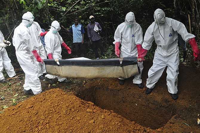 In this Oct. 18 photo, a burial team in protective gear bury the body of a woman suspected to have died from Ebola virus in Monrovia, Liberia. The disease has ravaged a small part of Africa, but the international image of the whole continent is increasingly under siege, reinforcing some old stereotypes. 