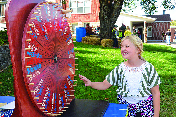 Zoe Rehagen, 9, spins the wheel, hoping it lands on the state she picked at Sunday's annual St. Joseph Catholic Church Fall Festival in Westphalia. The $1 game gives players a 1-in-50 chance of winning seven pounds of rope sausage.