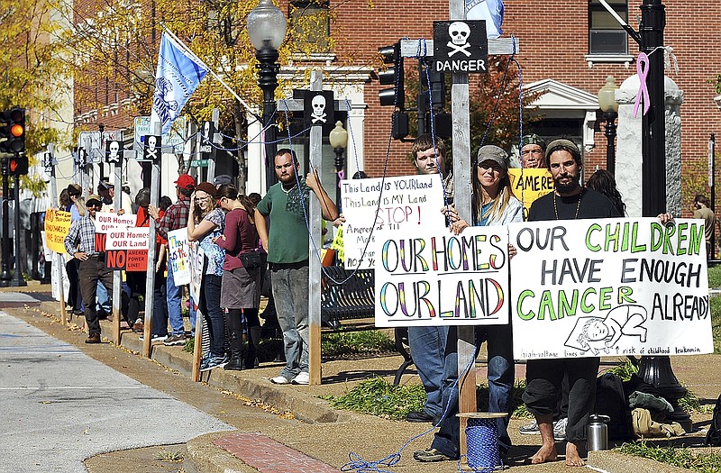 Julie Smith/News Tribune
Tyler Sheaffer, foreground right, and Deb Van Poolen, both of La Plata, stand next to one of several two-by-four poles made to simulate electric transmission lines. They were just a couple of the dozens of protestors gathered Monday outside the Cole County Courthouse before an eminent domain hearing involving Ameren of Illinois.
