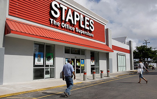  In this Tuesday, Nov. 15, 2011, file photo, customers enter Staples office supply store in Miami. 