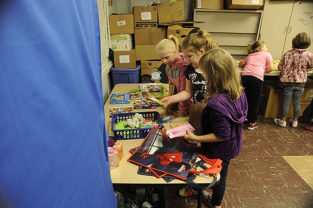 Veronika Lyman, Maisie Maier and Meredith Benne, second graders in Sarah Kennedy's class, enjoy "shopping" at the Russellville PTO Store. The store is offered at the end of each quarter for students to exchange tickets earned for attendance, character and academics for donated toys, books and trinkets.