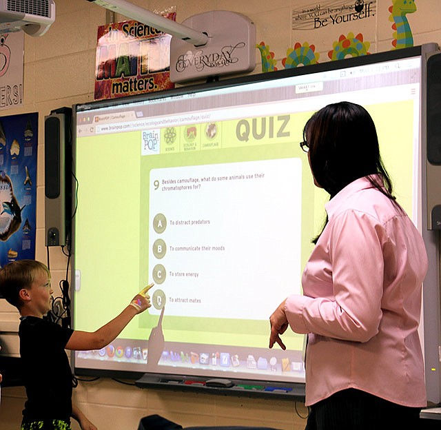 South Callaway science teacher Champagne Minx gives students a quiz over course material in class. Students selected the correct answer on the classroom's smartboard.
