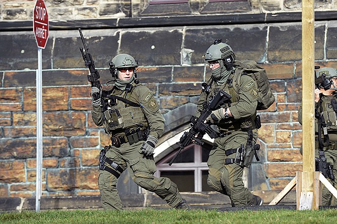 A Royal Canadian Mounted Police intervention team responds to a reported shooting at Parliament building in Ottawa Wednesday. A soldier standing guard at the National War Memorial was shot by a gunman and there were reports of gunfire inside the halls of Parliament. 