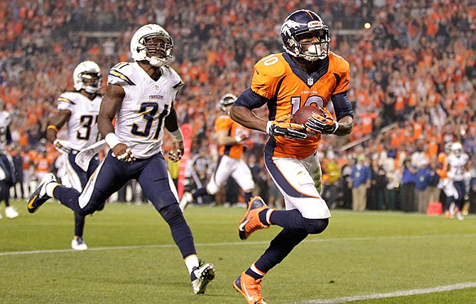 Denver Broncos wide receiver Emmanuel Sanders (10) scores his second touchdown of the NFL football game, as San Diego Chargers cornerback Richard Marshall (31) defends during the first half Thursday, Oct. 23, 2014, in Denver. 