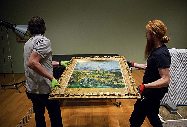 In this Oct. 14, photo, preparators Ed Hill, left, and Tommy Sapp, carry Paul CÃ©zanne's "Mont Sainte-Victoire" before it's hung as part of the High Museum's new exhibit, "Cezanne and the Modern: Masterpieces of European Art from the Pearlman Collection," in Atlanta.