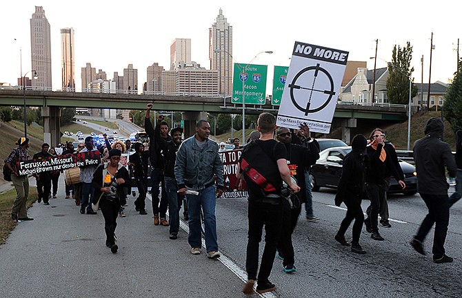 Protesters head up Freedom Parkway in Atlanta, Ga., after briefly shutting down the Downtown Connector's Northbound lanes Wednesday evening Oct. 22, 2014, during a protest that organizers said was part of a national week of resistance to mass incarceration and police brutality as well as the shooting of Michael Brown in Ferguson, Mo.