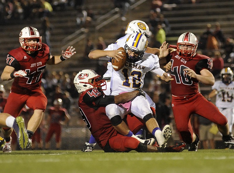 Jefferson City defensive end Jermiez Booker crashes into the Hickman backfield and drags down quarterback Carter Nicoli for a sack Friday night at Adkins Stadium.
